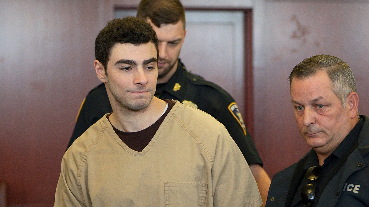 Luigi Mangione seated in court as judge drops terrorism charges.