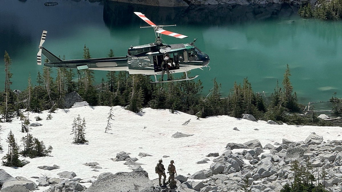 Helicopter joins in search for Travis Decker in an undisclosed location. Photo of helicopter, blue water and white snow.
