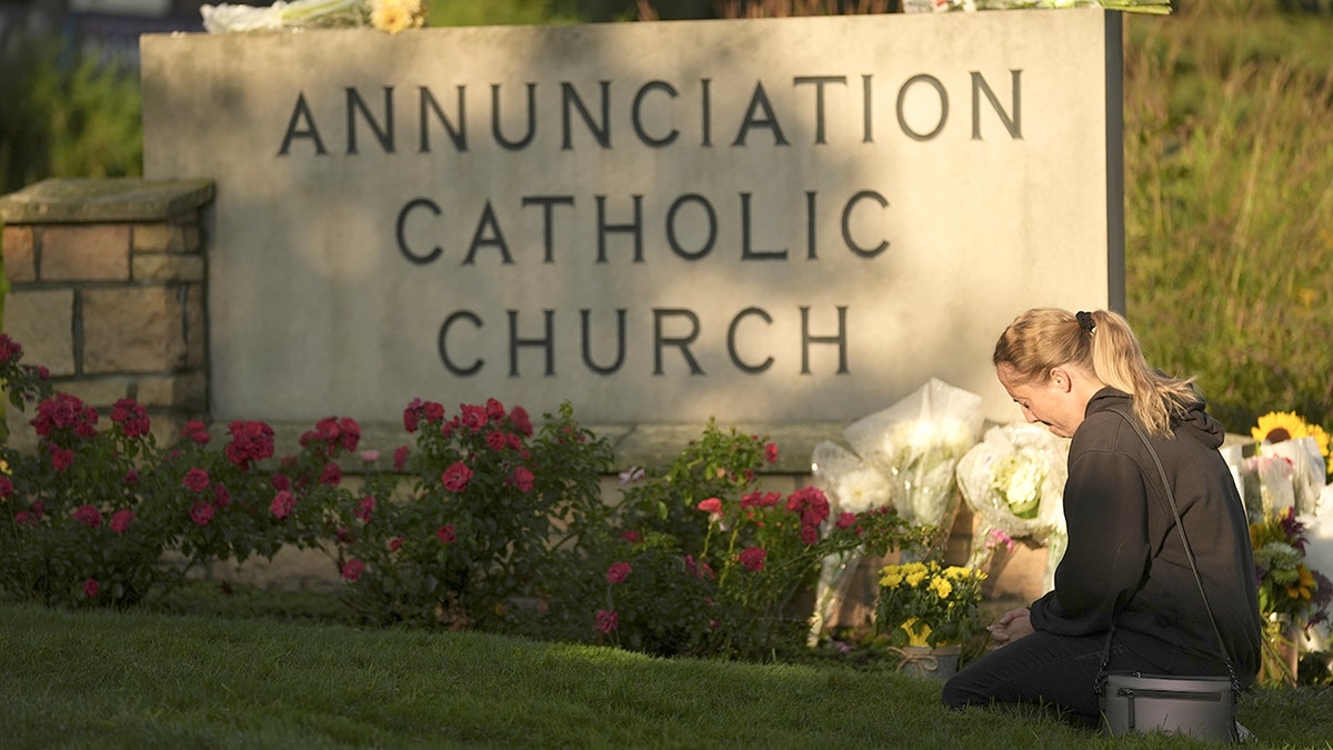 Mourners visit a memorial set up for victims of the mass school shooting at a Catholic school church.