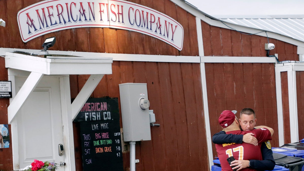 A man hugs a police officer following a shooting