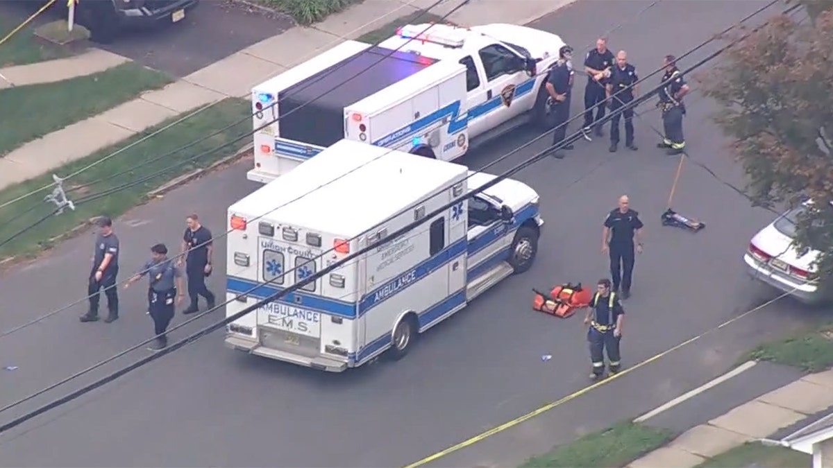 Police officers gather at the scene where two teens were killed.