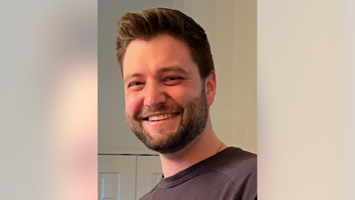 Brandon Dumovich smiling with a brown T-shirt on.