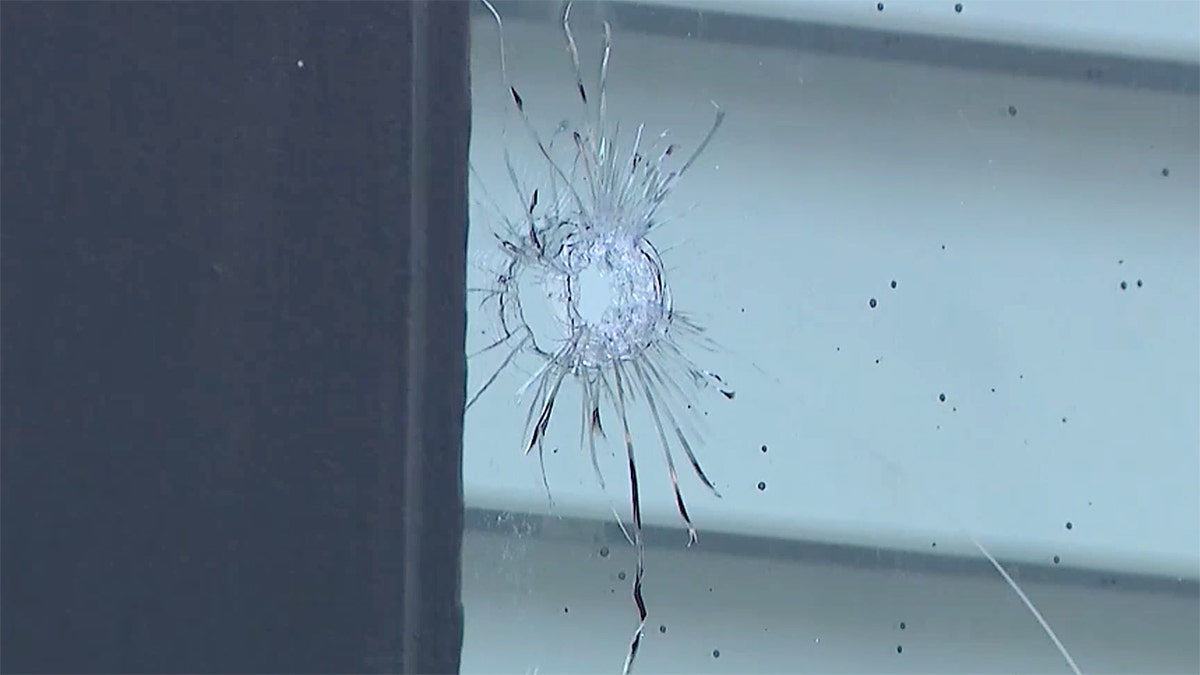 Apparent bullet hole in window of home