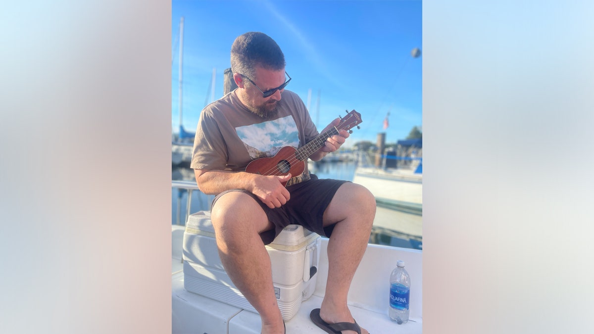 Dennis "D.J." Thornlow playing a guitar.