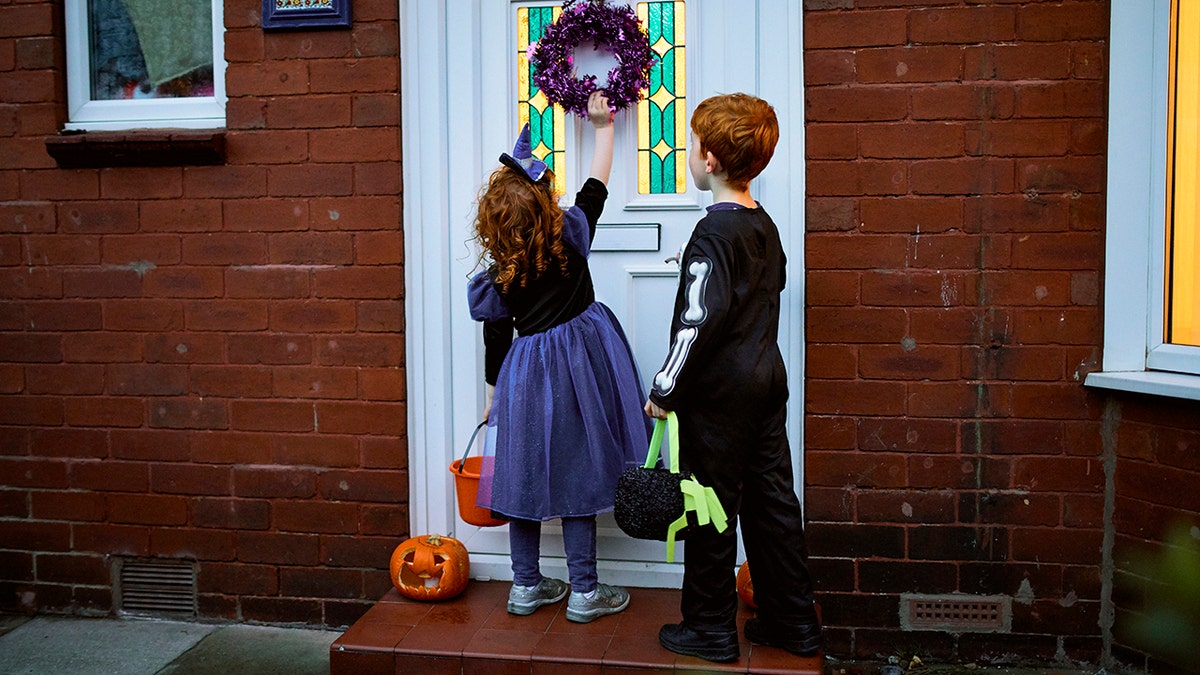 Two kids dressed in costumes while trick-or-treating