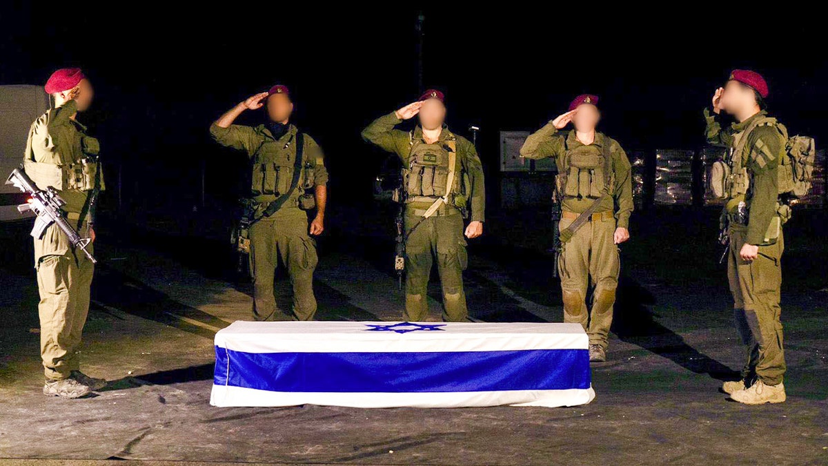 Israeli soldiers salute coffin draped with Israeli flag