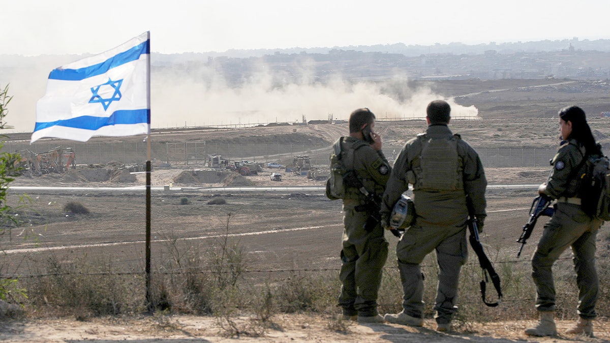 Israeli soldiers watch the northern Gaza Strip from southern Israel.