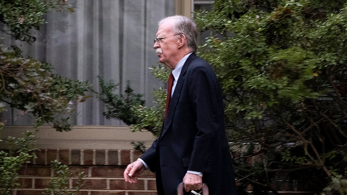 John Bolton walks out of his house in Maryland
