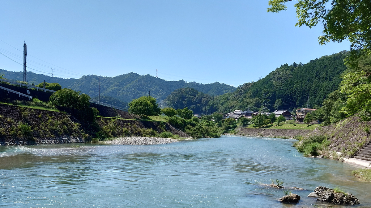 A landscape shot shows a large stream with Japan's Tenkawa Village in the background.