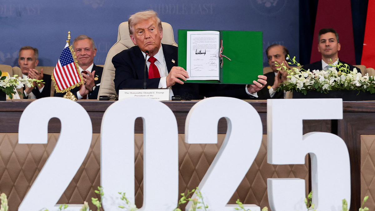 Trump holding up signed agreement for peace in Gaza.