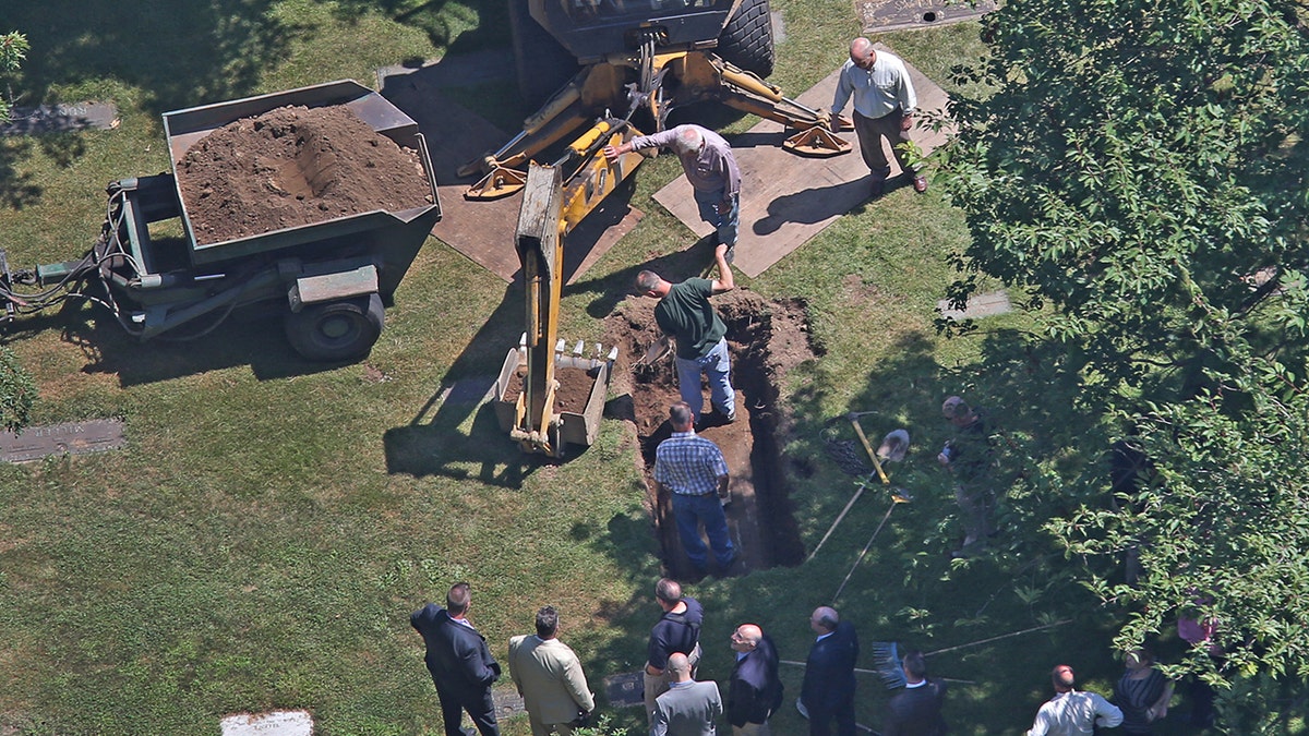 Men digging up the remains of Albert DeSalvo.