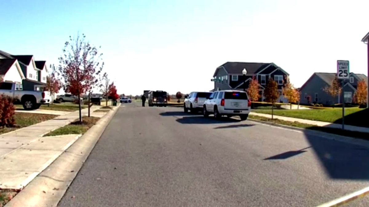 emergency vehicles and police tape near a home where a shooting happened