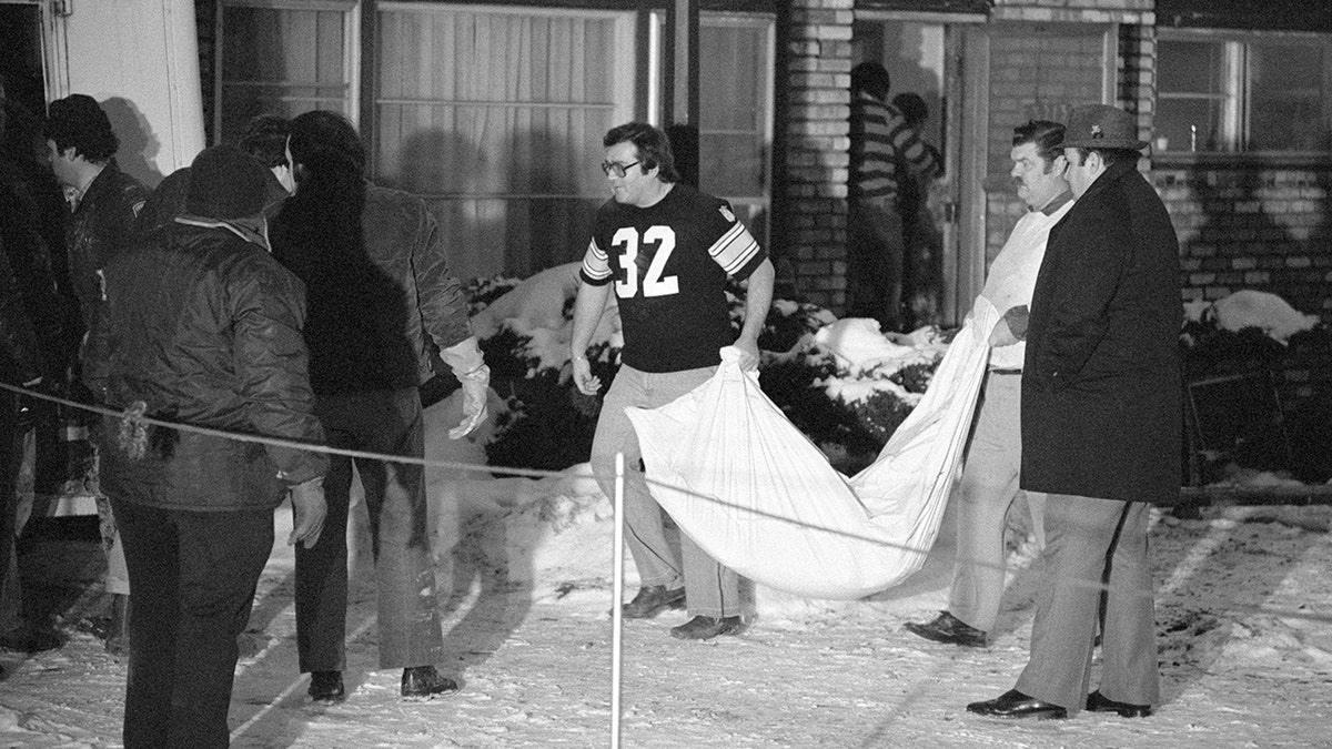 Men pulling out victims from John Wayne Gacy's home.