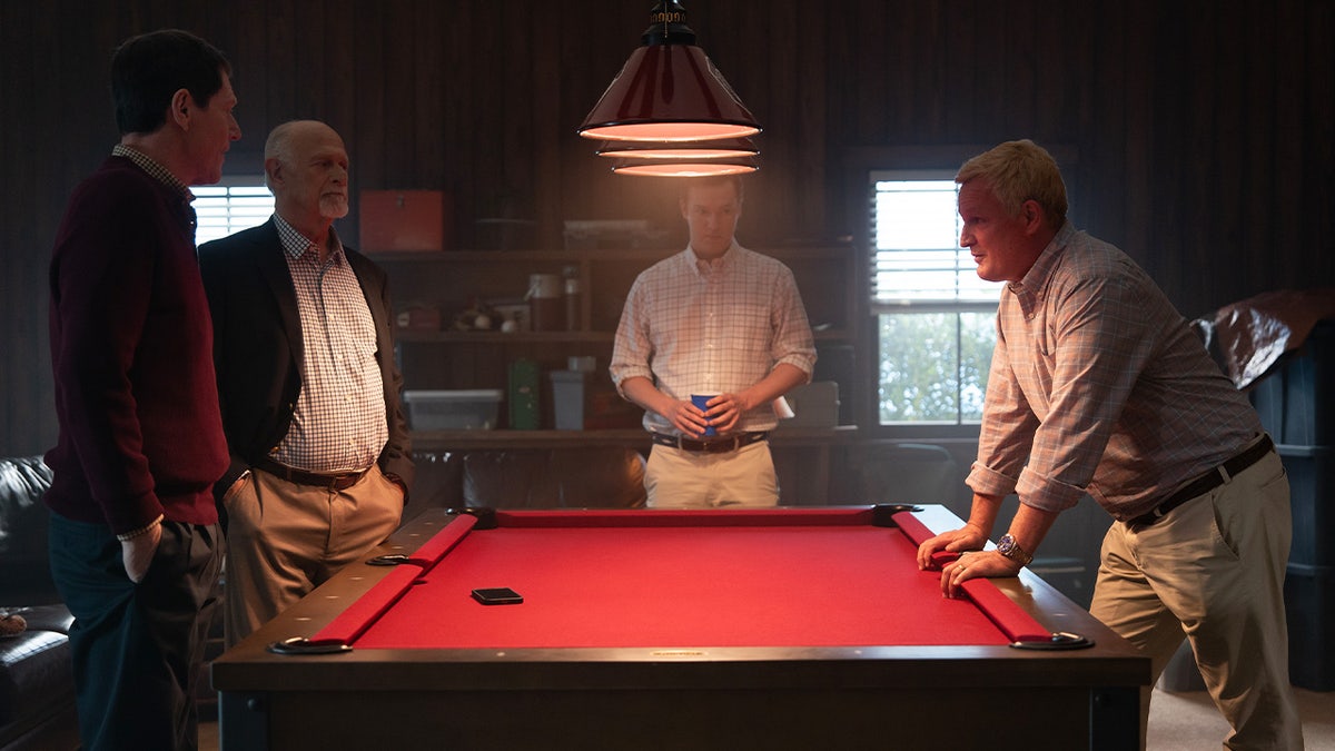 Noah Emmerich, Gerald McRaney, Will Harrison, and Jason Clarke sit and stand around a desk during a serious conversation in Murdaugh: Death in the Family episode 