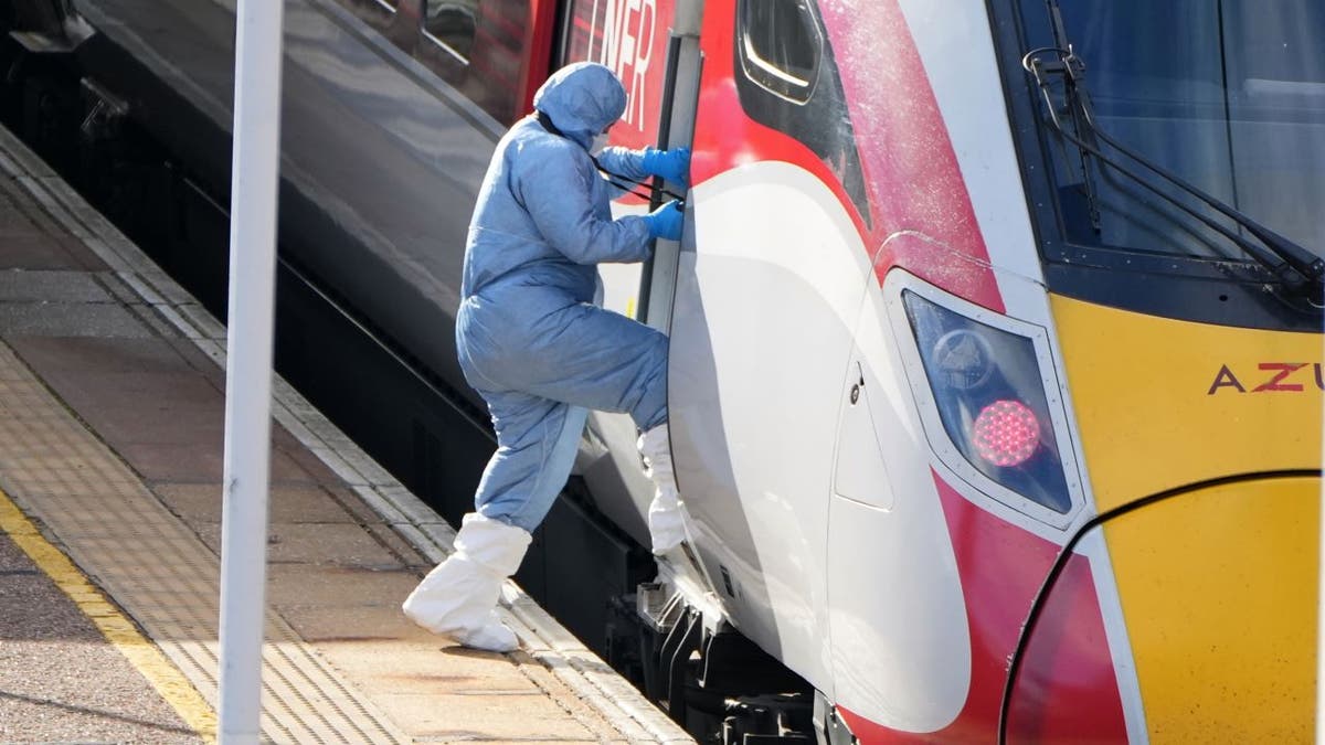 An investigator enters the scene of a train stabbing in the UK