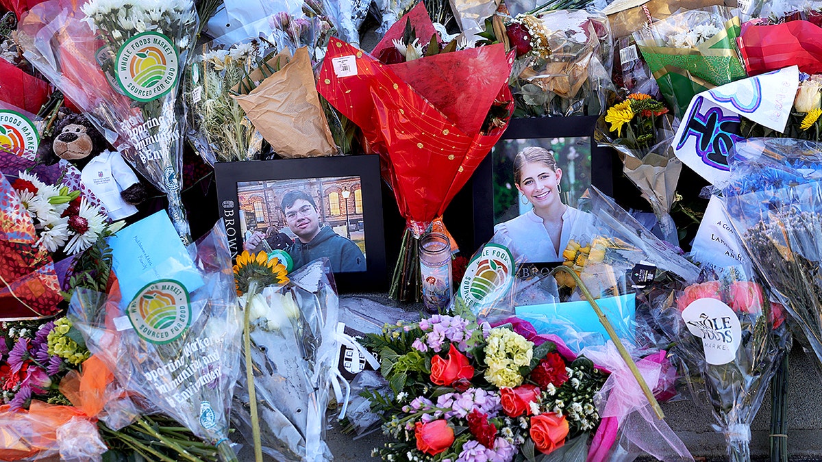 Flowers surround photos of two Brown students who were murdered on campus in early Dec.