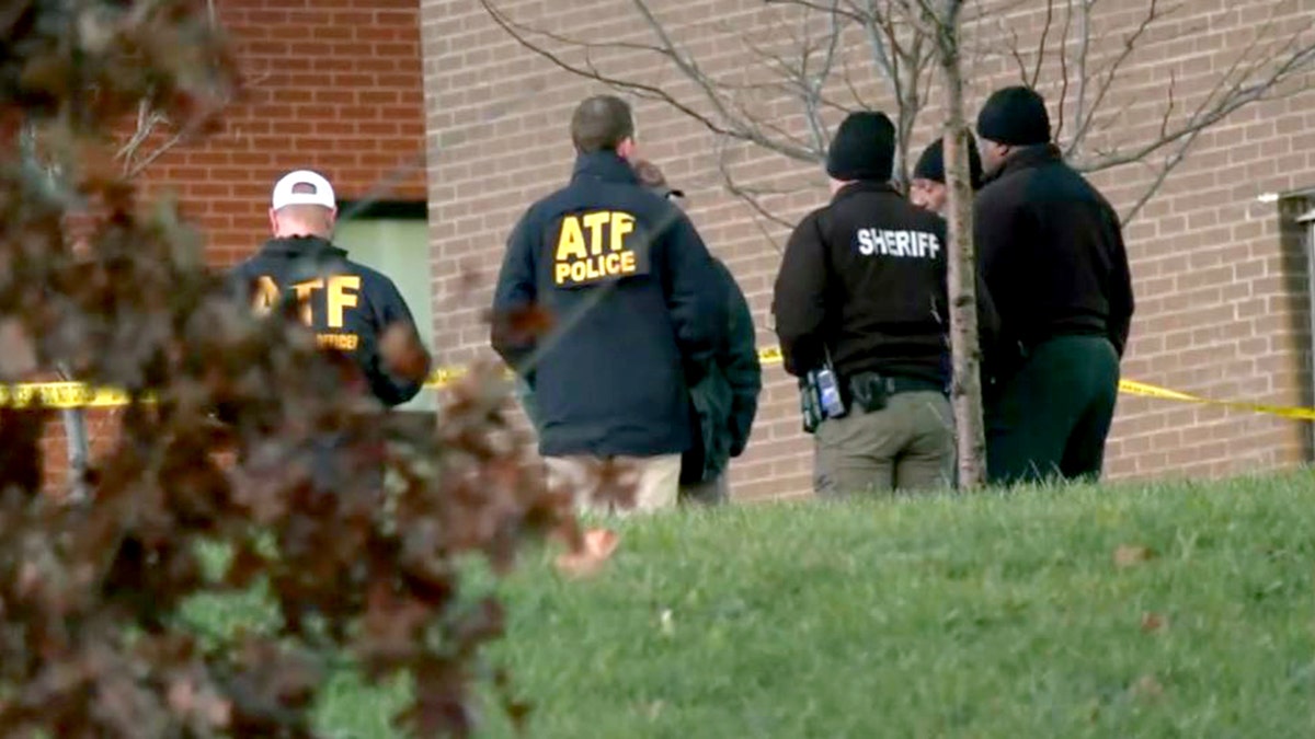 law enforcement officials speaking outside residence hall