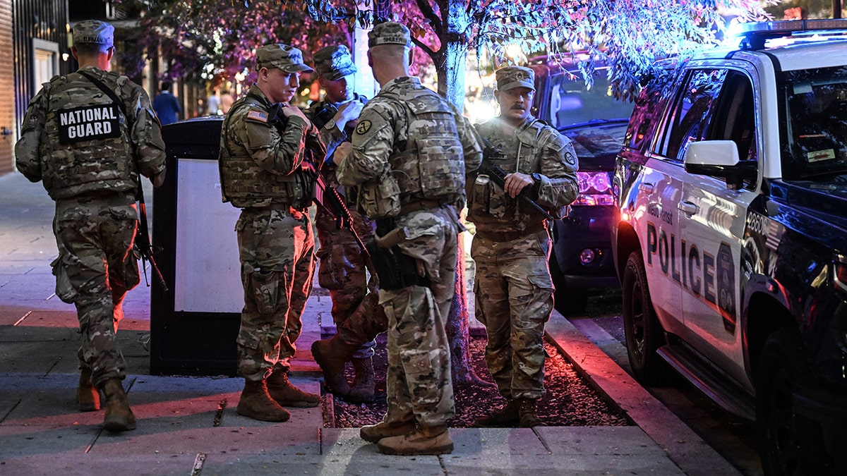 National Guard members stand on a sidewalk in Washington, DC