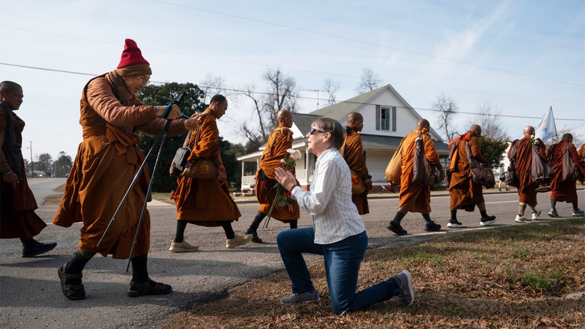 woman greets buddhist monk