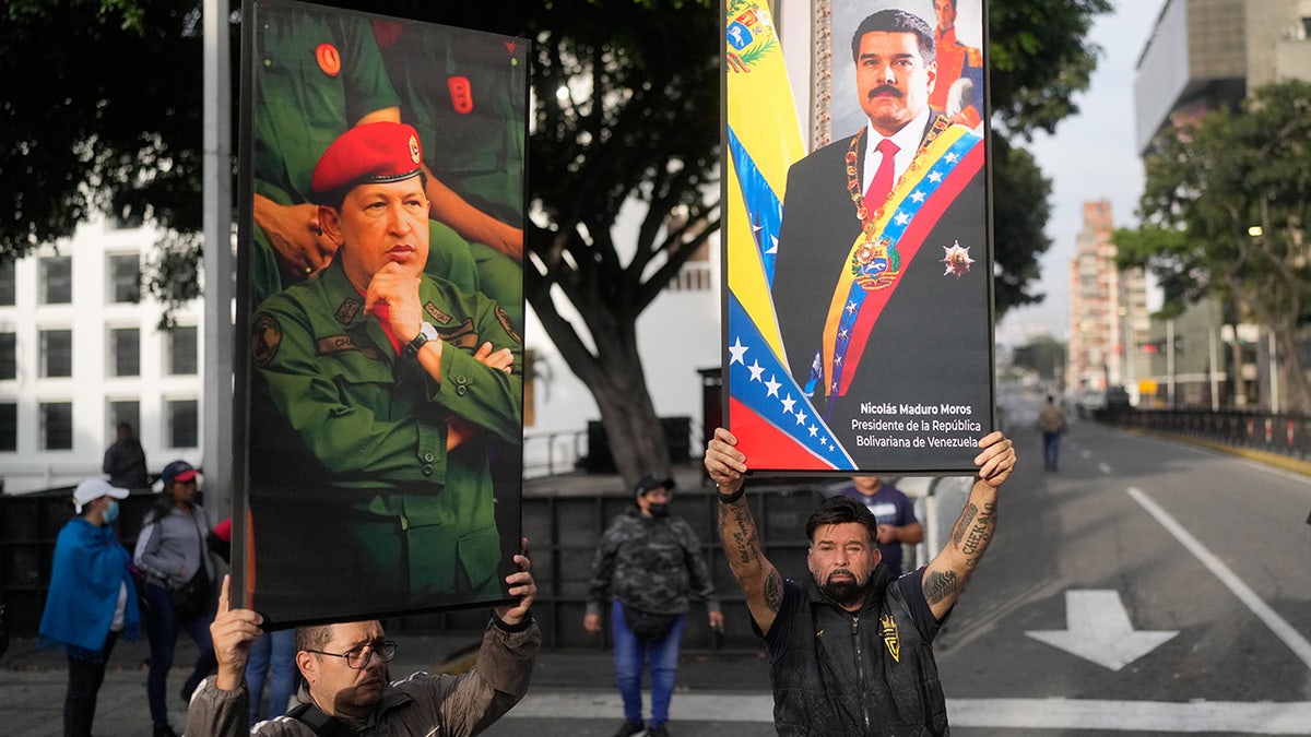Venezuelans hold posters of Hugo Chávez and Nicolás Maduro in streets of Caracas
