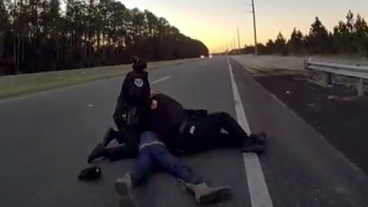 Deputies hold down the suspect in a road during a traffic stop in Florida.