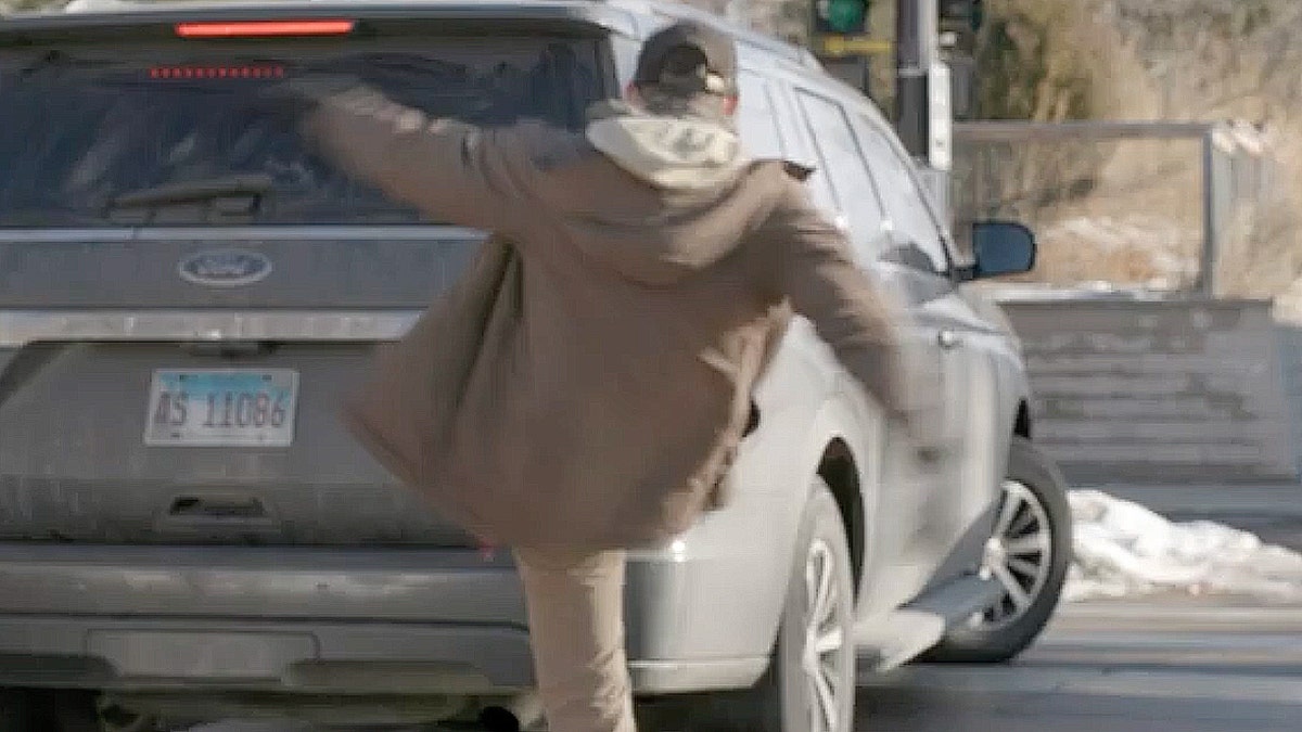 A man kicking a car