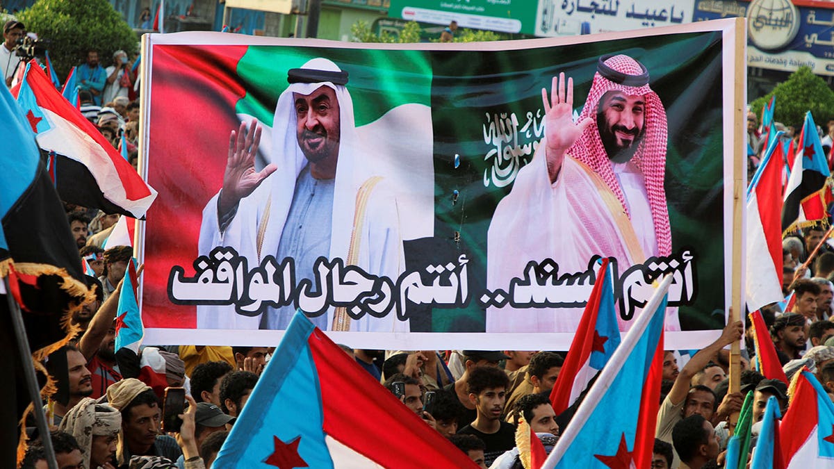 People hold a banner with images of the President of the United Arab Emirates, Sheikh Mohamed bin Zayed Al Nahyan, and Crown Prince and Prime Minister Mohammed bin Salman of Saudi Arabia during a rally organised by Yemen's main separatist group, the Southern Transitional Council (STC), in Aden, Yemen Dec. 21, 2025.
