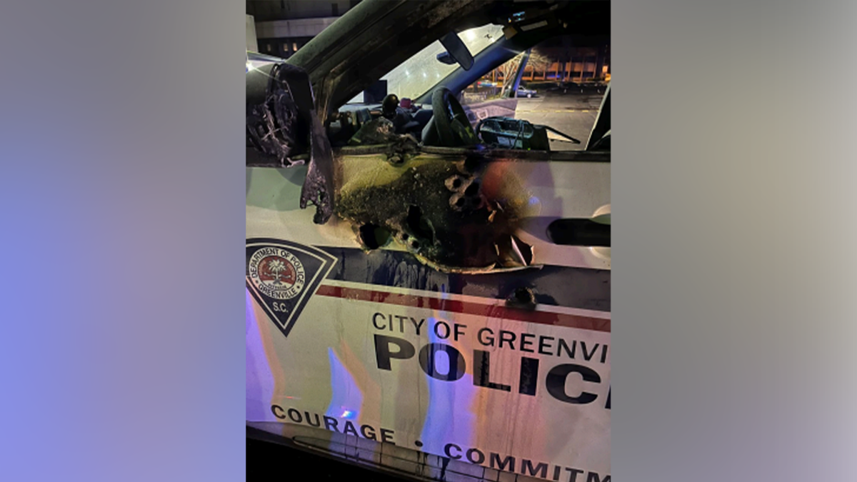 A Greenville police patrol vehicle shows damage to the driver-side door following a shooting
