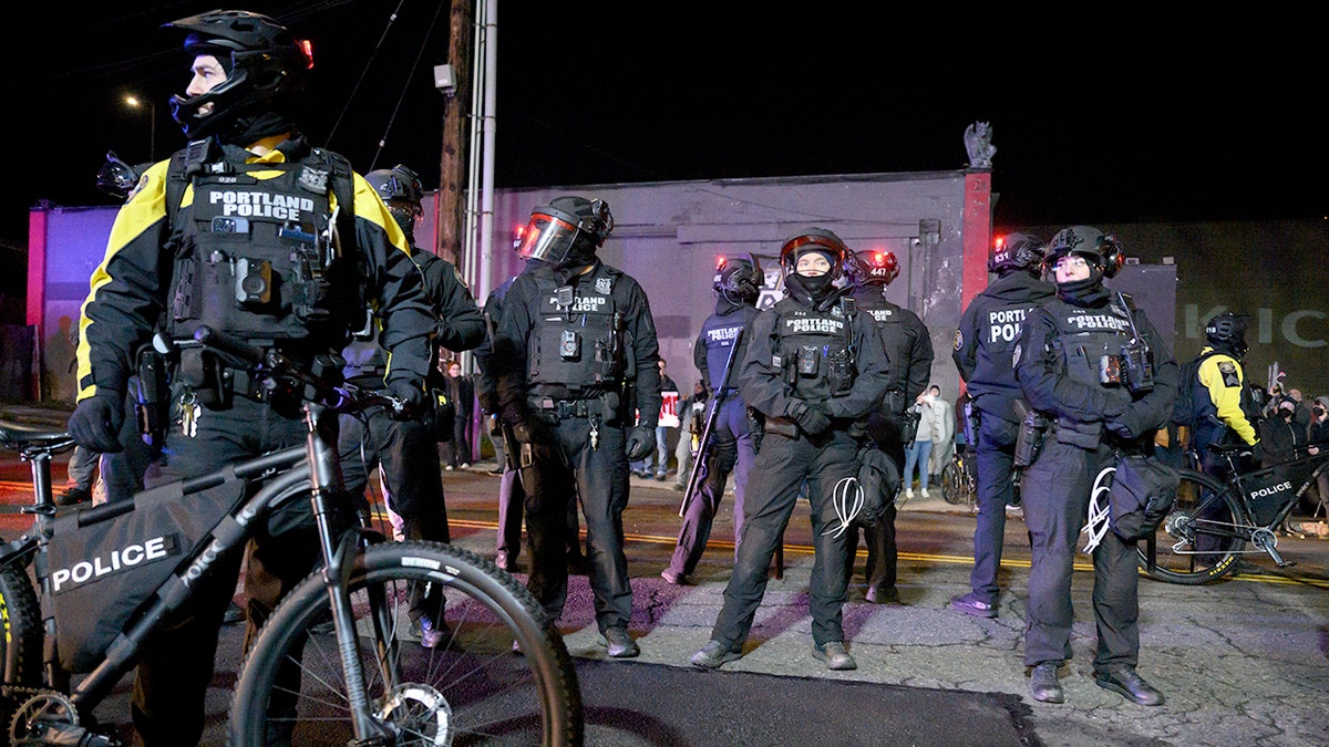 Portland police officers stand at anti-ICE protest