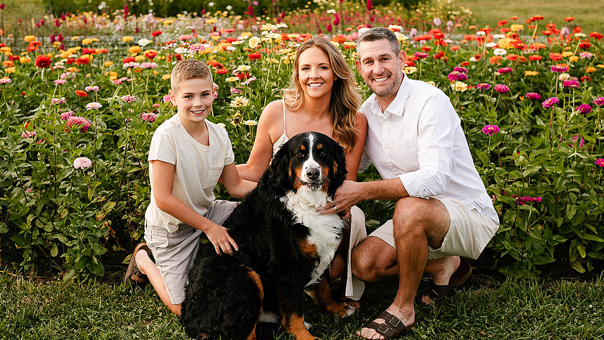 The Pung family posing with dog in flower field