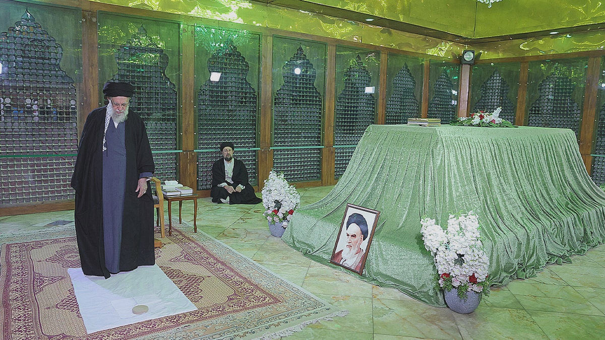 Ali Khamenei standing on a white mat.