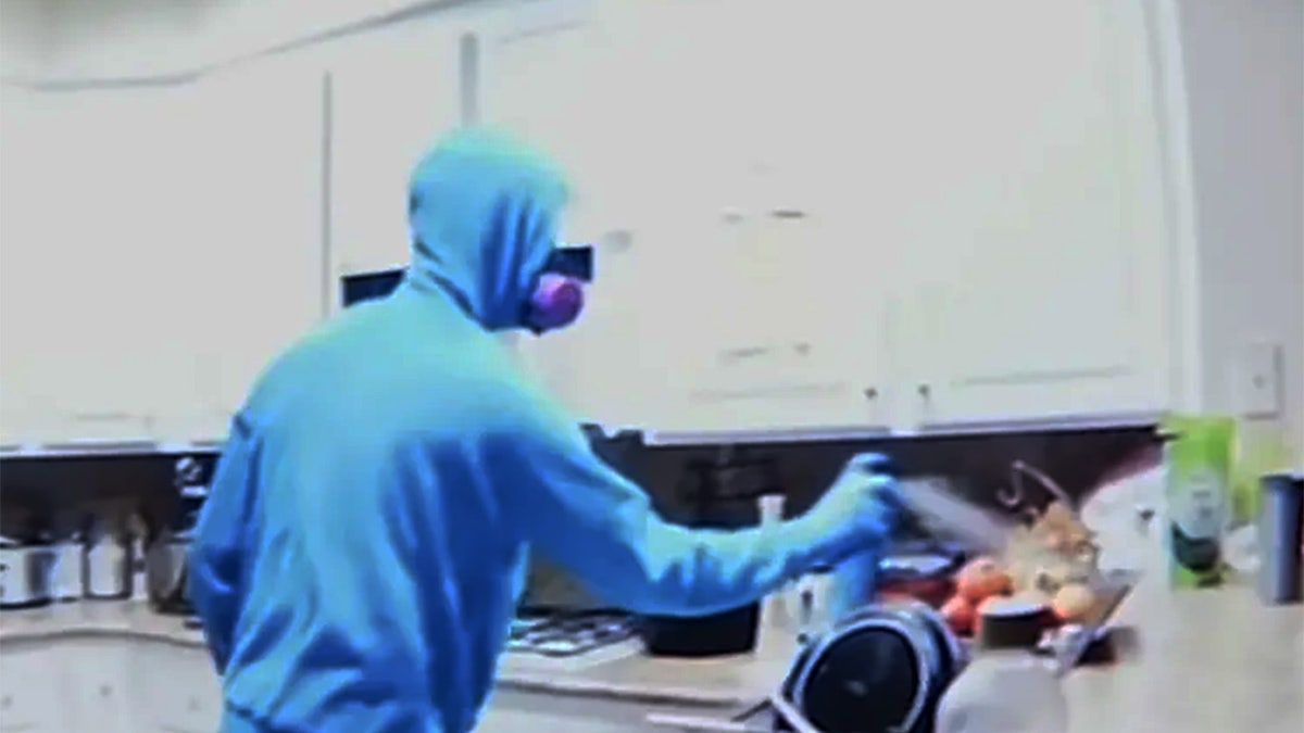 Suspect seen spraying blue bottle with alleged poison.