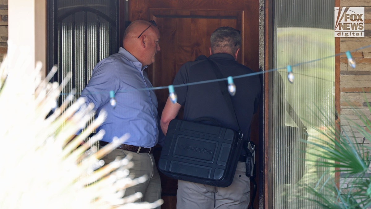 An investigator transports specialized monitoring equipment the Annie Guthrie residence.