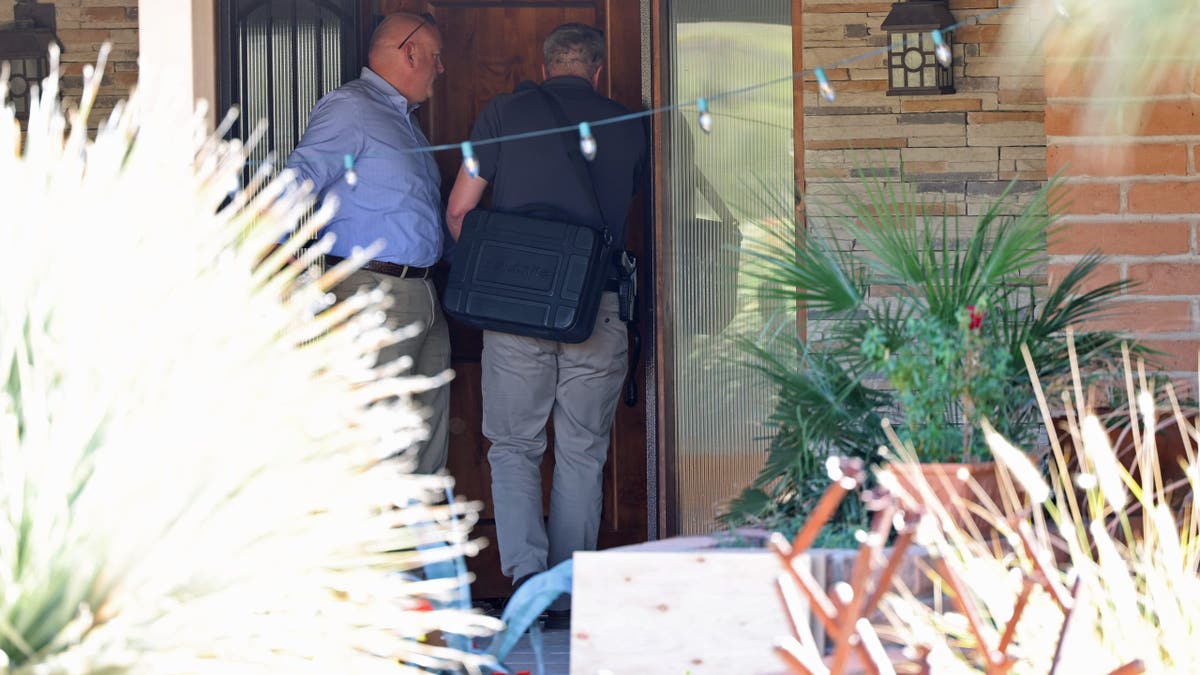An investigator transports specialized monitoring equipment the Annie Guthrie residence.