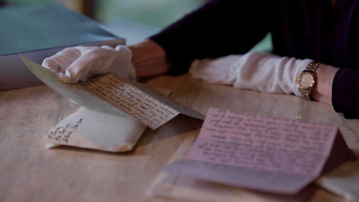 Edna Martin holding letters written by Ted Bundy.