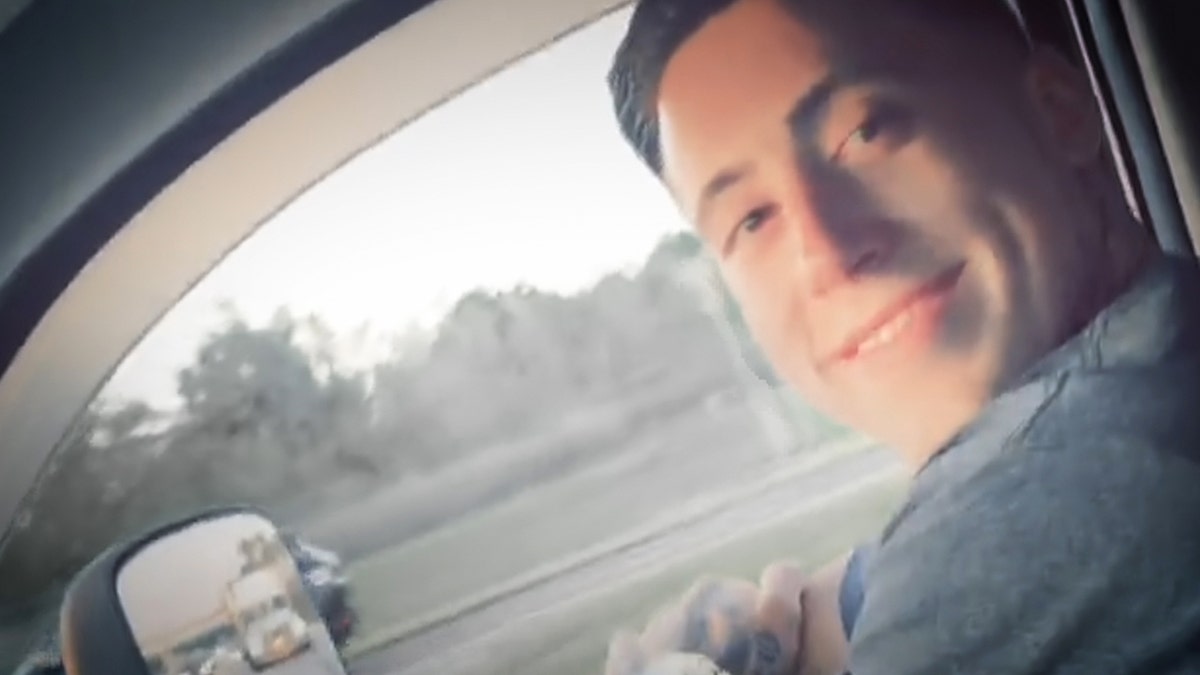 A young Wade Wilson smiling inside a car.