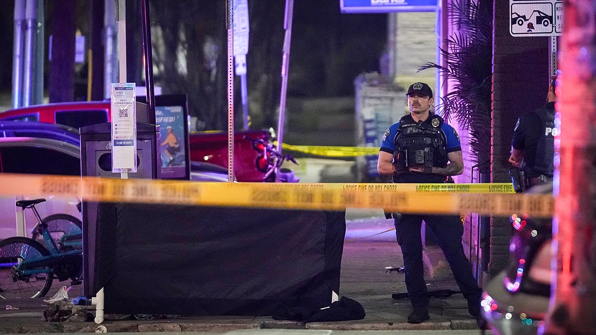Police standing in front of a bar where a shooting occurred.