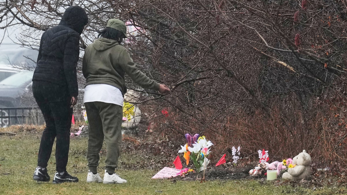 People visit a memorial at the site where two girls bodies were found